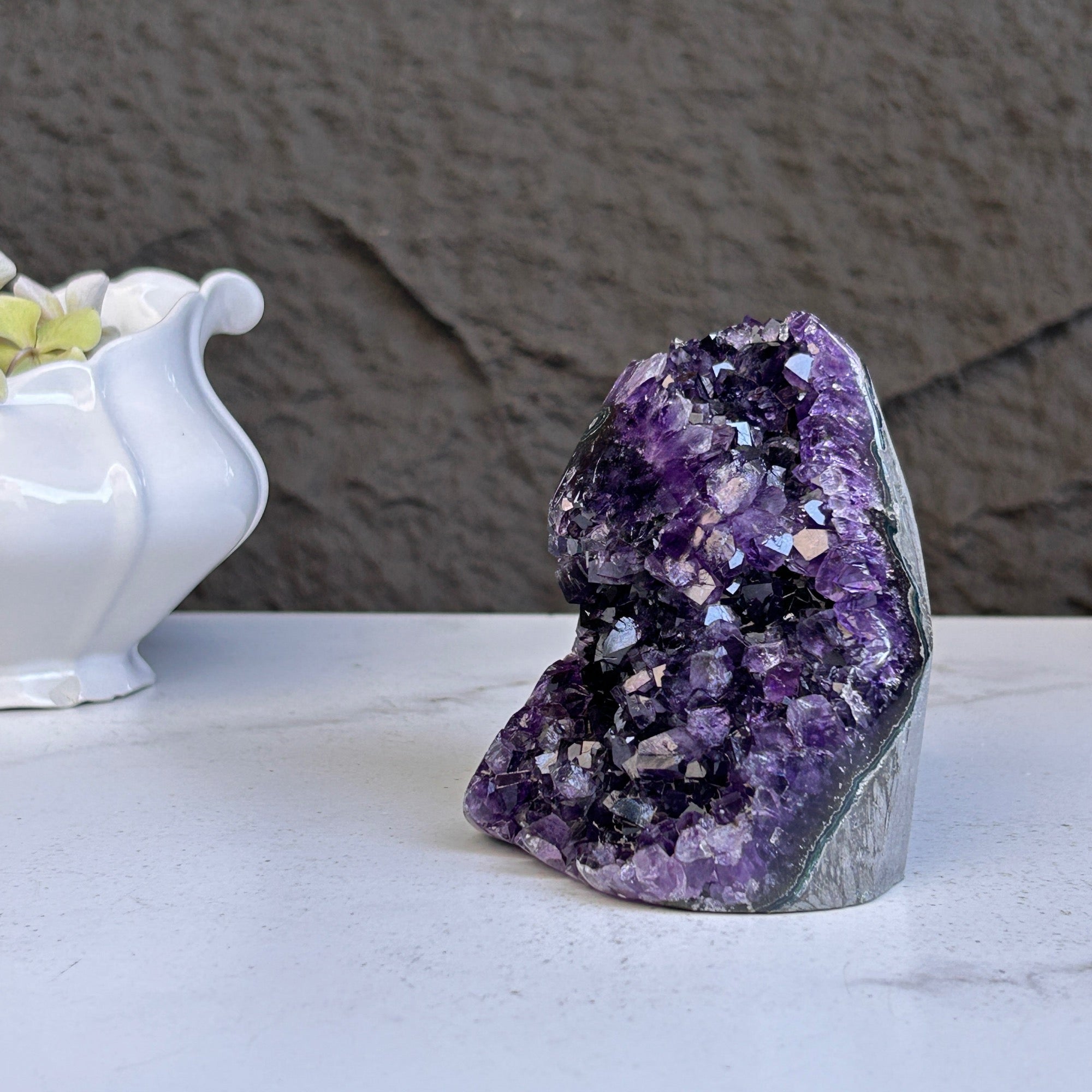 Large deep purple amethyst geode crystal cluster with sparkling formations.