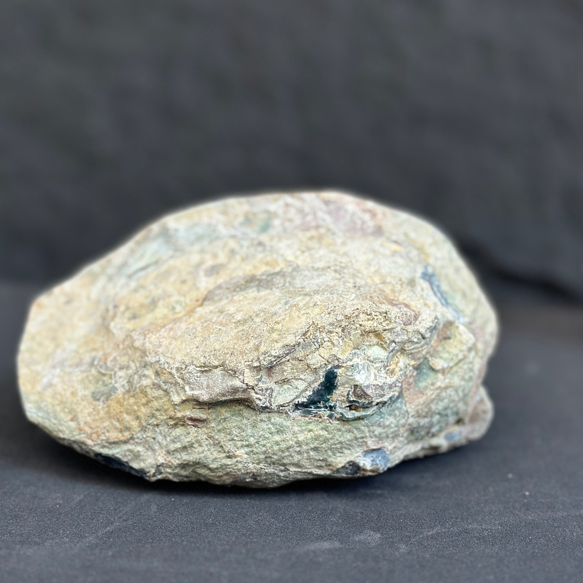 Rough, unpolished amethyst geode exterior with natural rock textures and earthy tones.