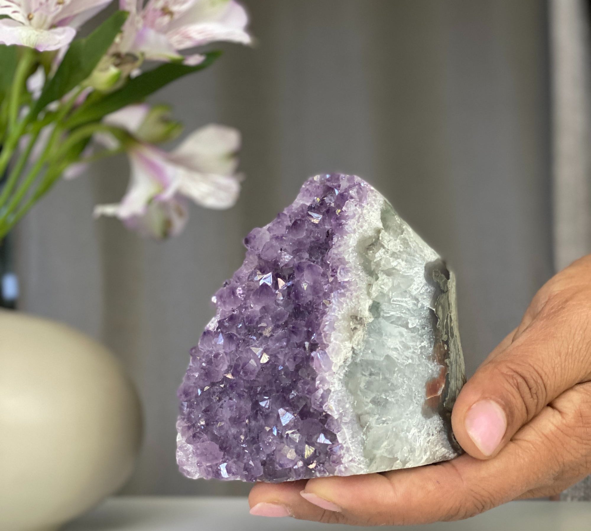 Vibrant lavender amethyst geode cluster with sparkling purple crystals and white agate formations.