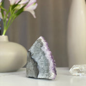 Sparkling lavender pink amethyst geode cluster with natural agate formations.