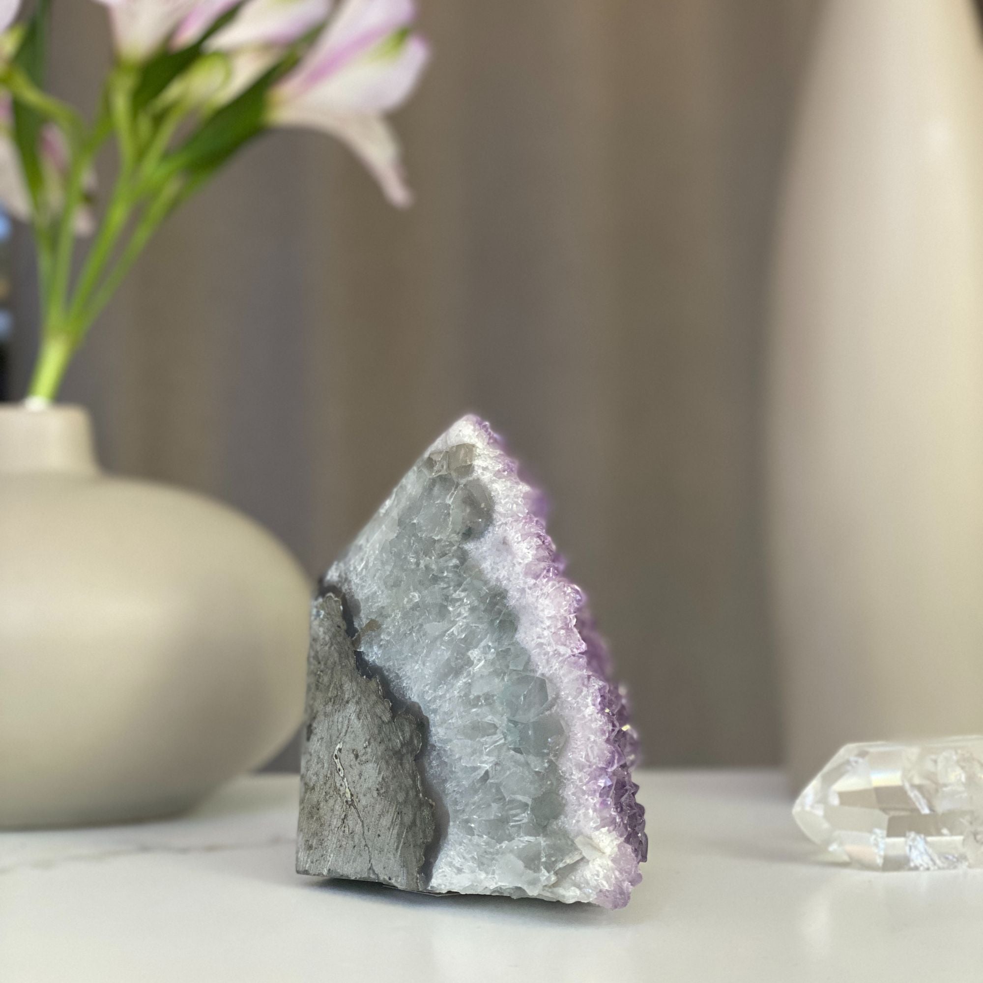 Sparkling lavender pink amethyst geode cluster with natural agate formations.