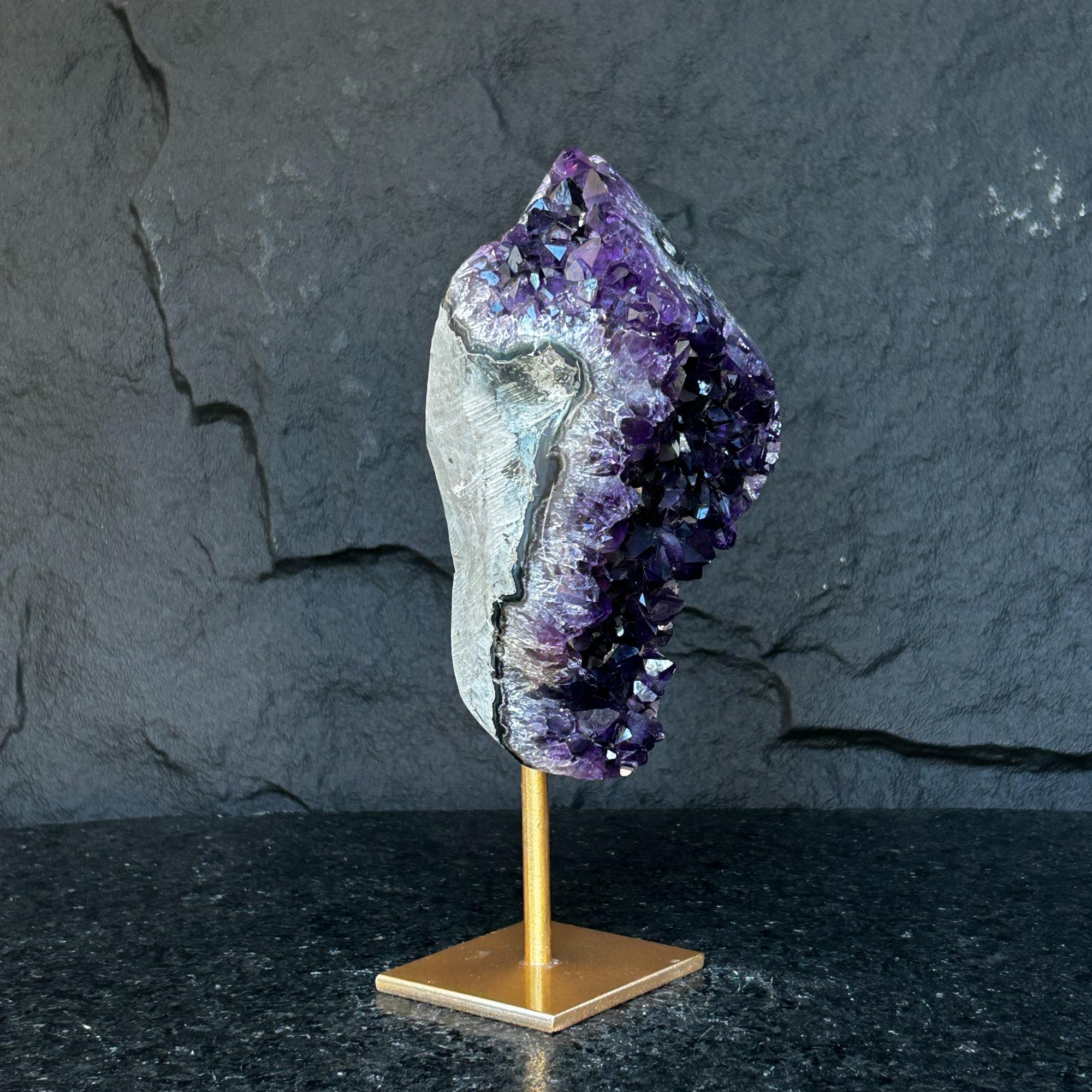 Natural Uruguayan amethyst cave crystal with deep purple geode on a gold metal stand.