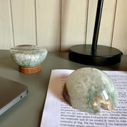 Crystal ball on a book with a lamp and lantern in the background.