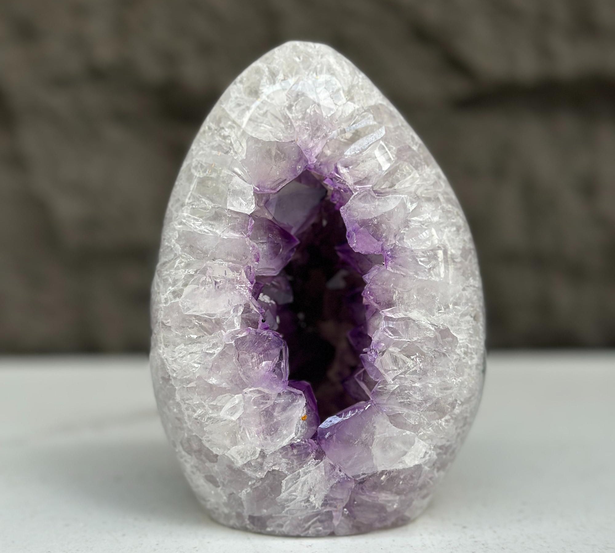 Polished amethyst geode egg, 5-inch tall, with sparkling purple crystals inside.