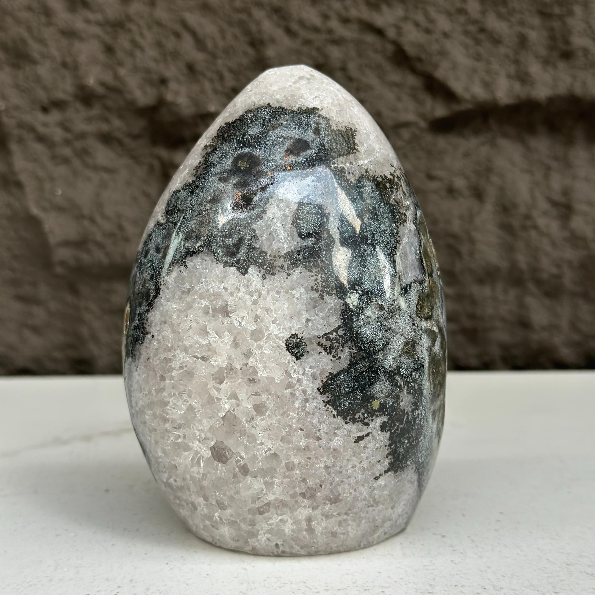 Polished 5-inch quartz, amethyst, and agate stone egg with black, white, and gray patterns.