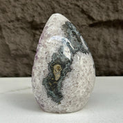 Polished quartz, amethyst, and agate stone egg, 5-inch tall, with dark and light natural patterns.