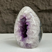 Polished 5-inch quartz, amethyst, and agate stone egg with a deep purple crystal geode interior.