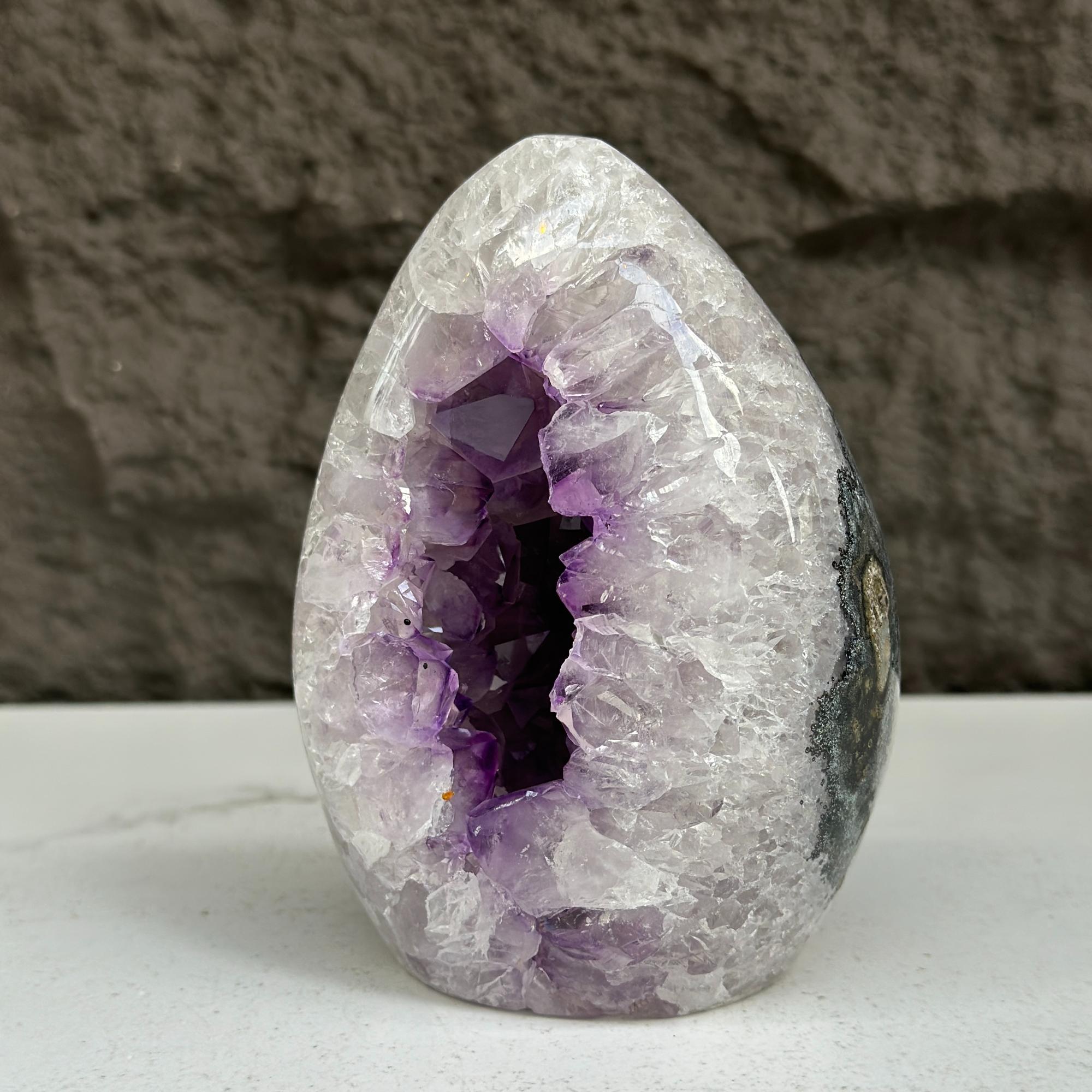 Polished 5-inch quartz, amethyst, and agate stone egg with a deep purple crystal geode interior.