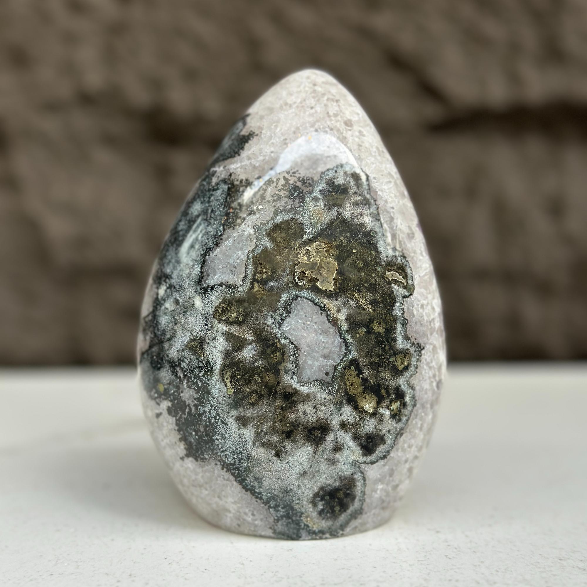 Polished quartz, amethyst, and agate stone egg, 5-inch tall, with dark and gold natural patterns.