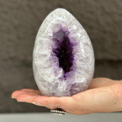 Polished quartz, amethyst, and agate stone egg, 5-inch tall, with deep purple crystal geode.