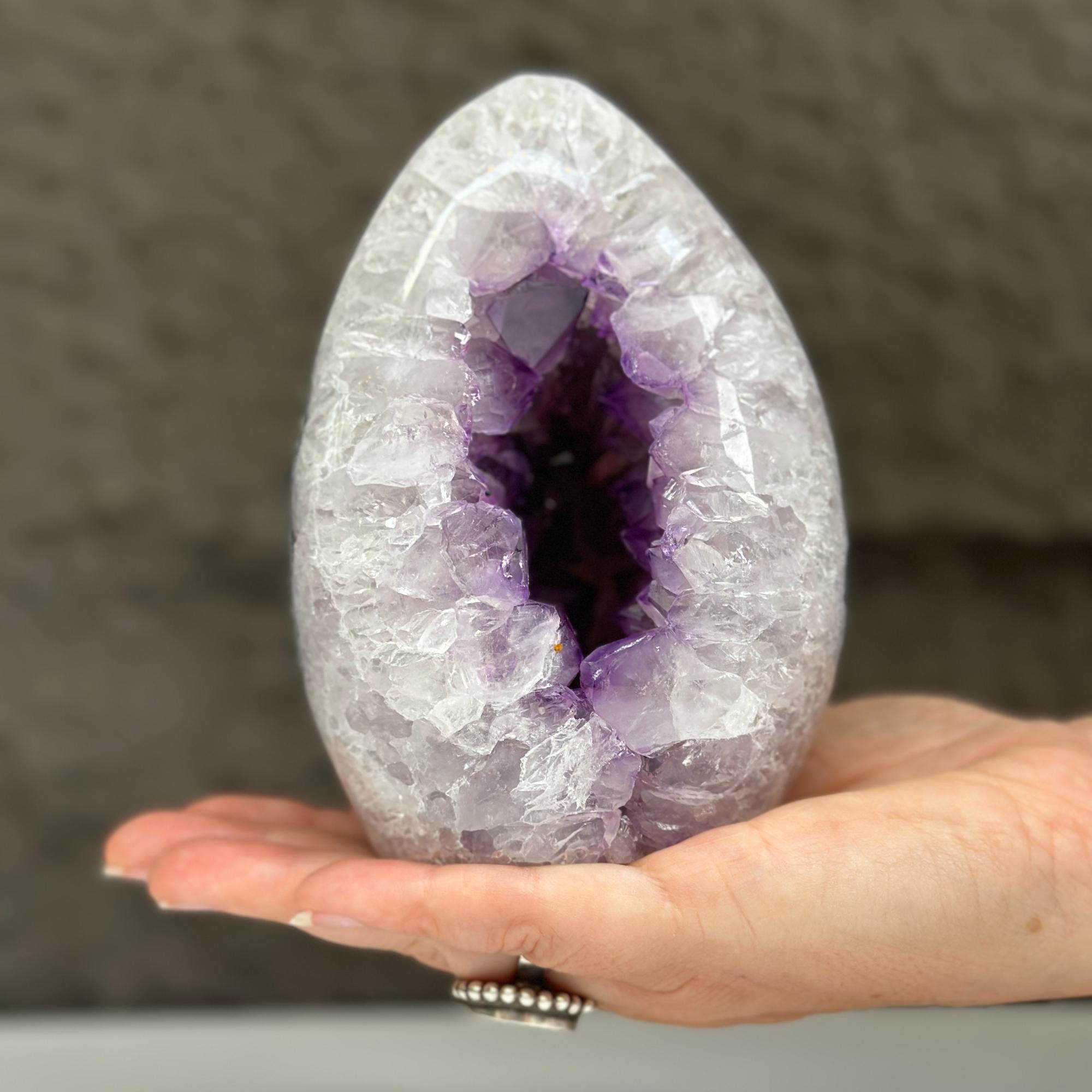 Polished quartz, amethyst, and agate stone egg, 5-inch tall, with deep purple crystal geode.