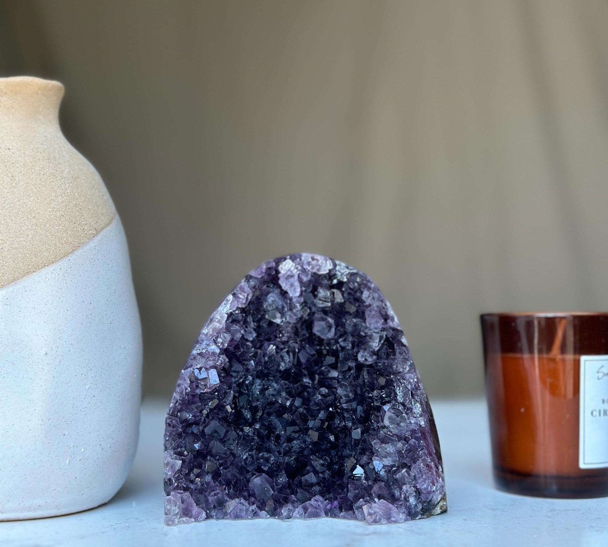 Large vibrant deep purple raw amethyst cathedral geode cluster with sparkling crystals.