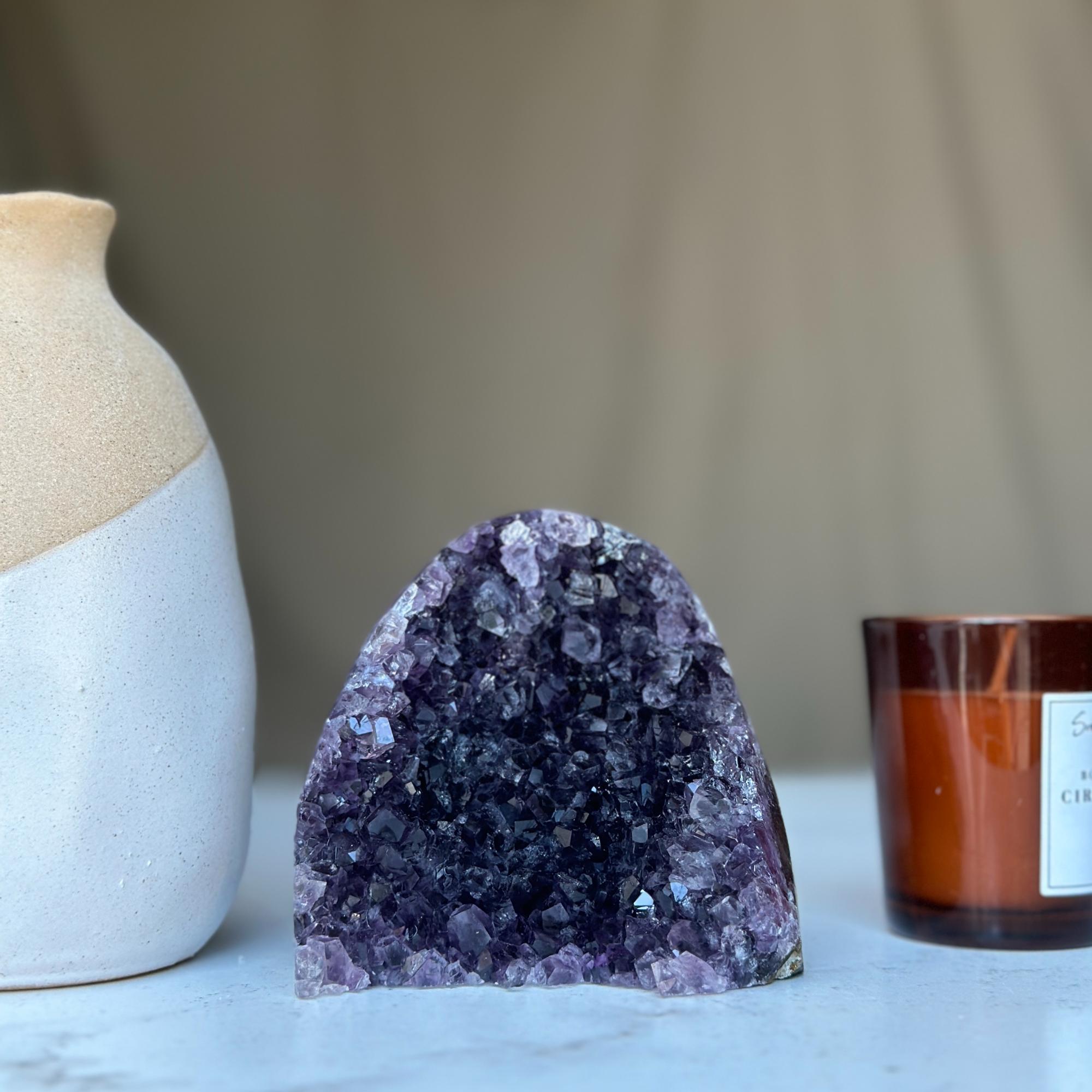 Large vibrant deep purple raw amethyst cathedral geode cluster with sparkling crystals.