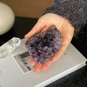 Hand holding a deep purple raw flat amethyst cluster with visible crystals, weighing 0.9 lb.
