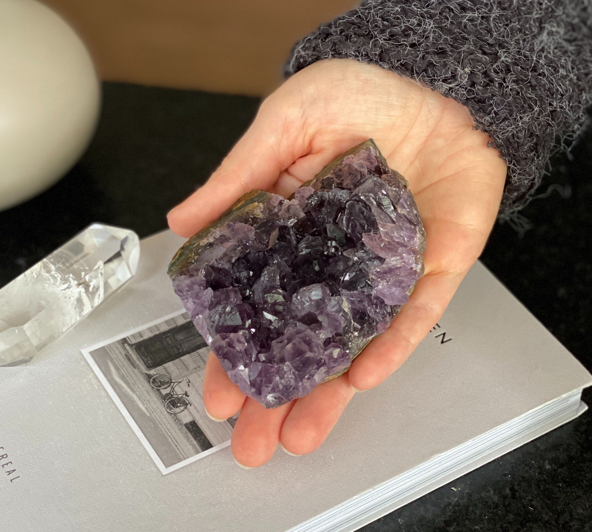 Hand holding a deep purple raw flat amethyst cluster with visible crystals, weighing 0.9 lb.