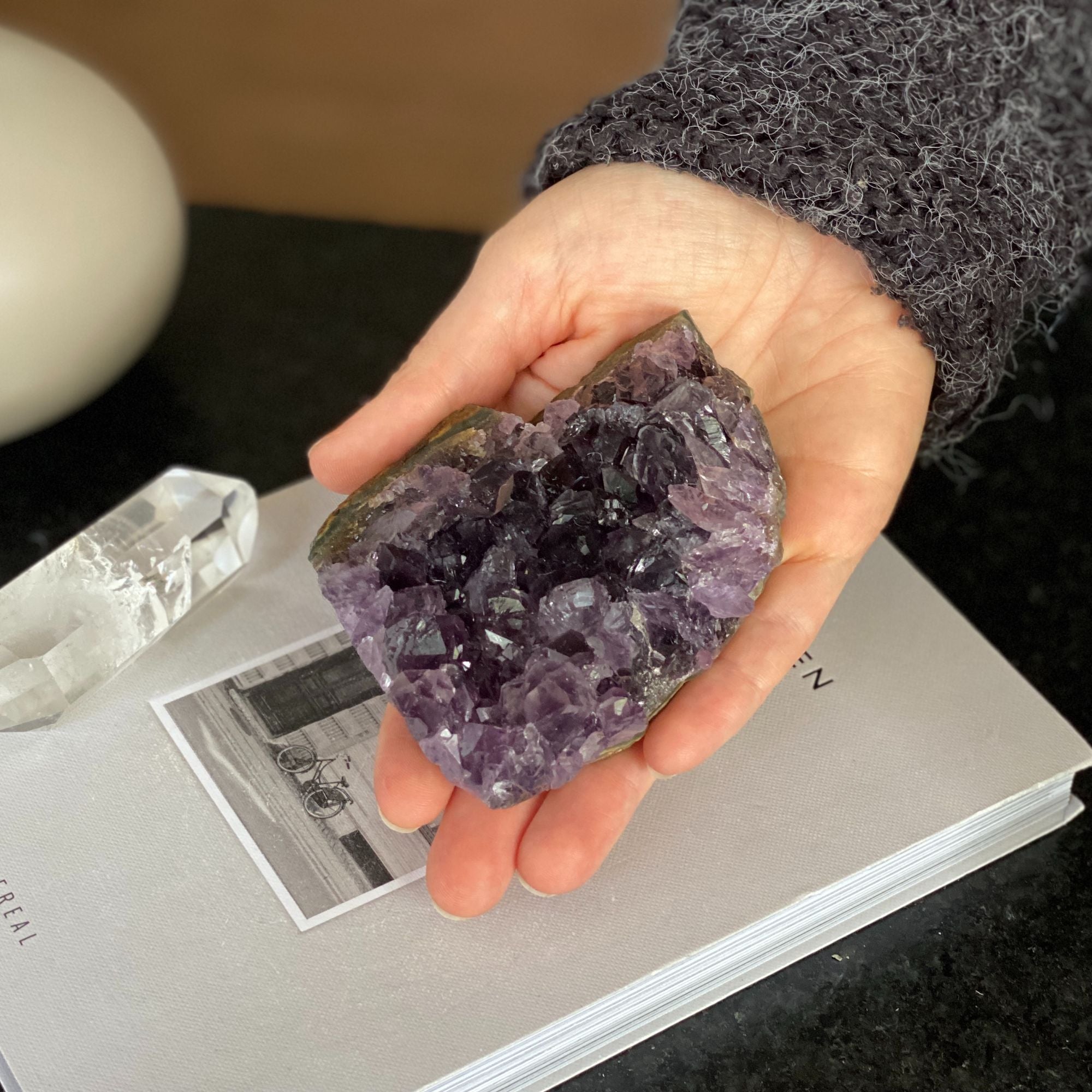 Hand holding a deep purple raw flat amethyst cluster with visible crystals, weighing 0.9 lb.
