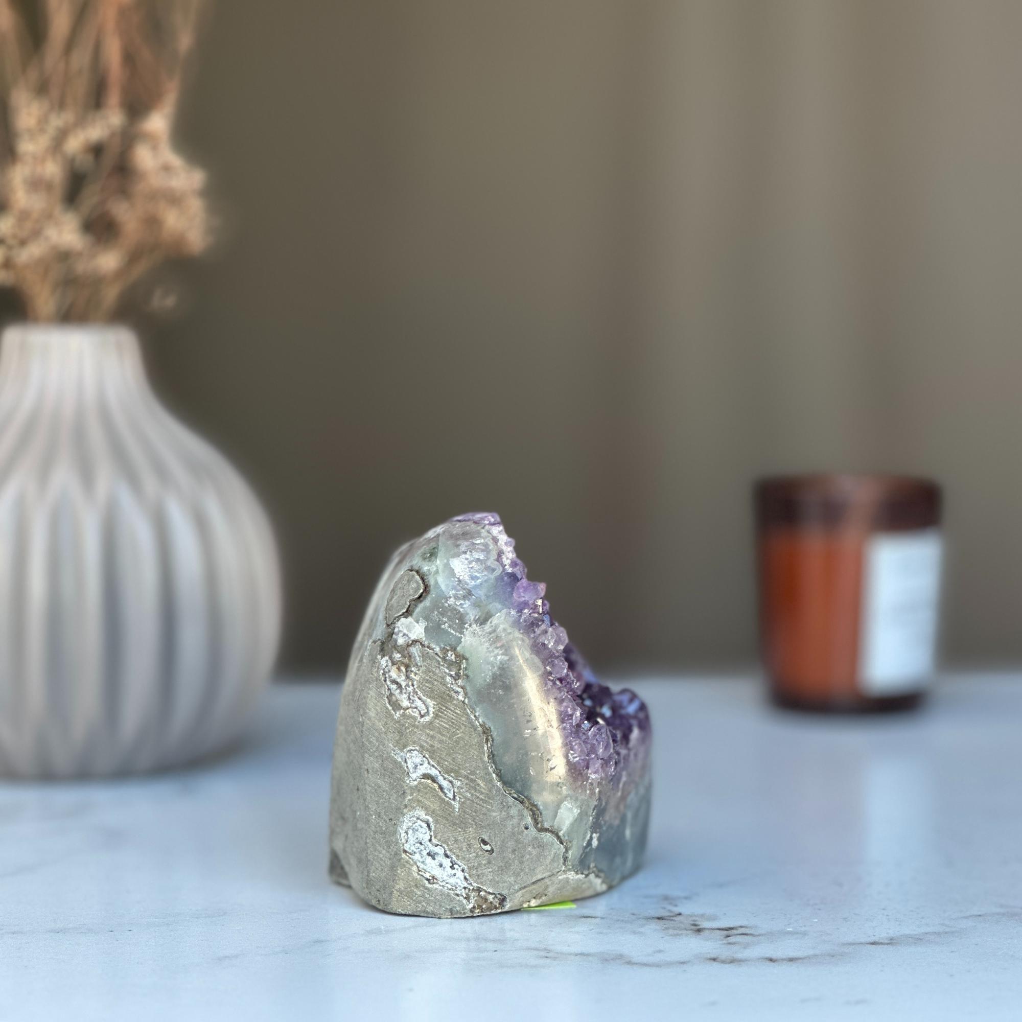 Raw purple amethyst geode cluster, 3.5-inch tall, with a grey exterior, on a white surface.