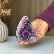 Hand holding a 3.5-inch tall raw purple amethyst geode crystal cluster.