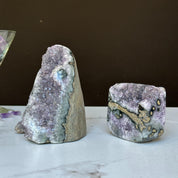 Two vibrant Uruguayan amethyst geode clusters with agate formations, one tall and one rectangular.