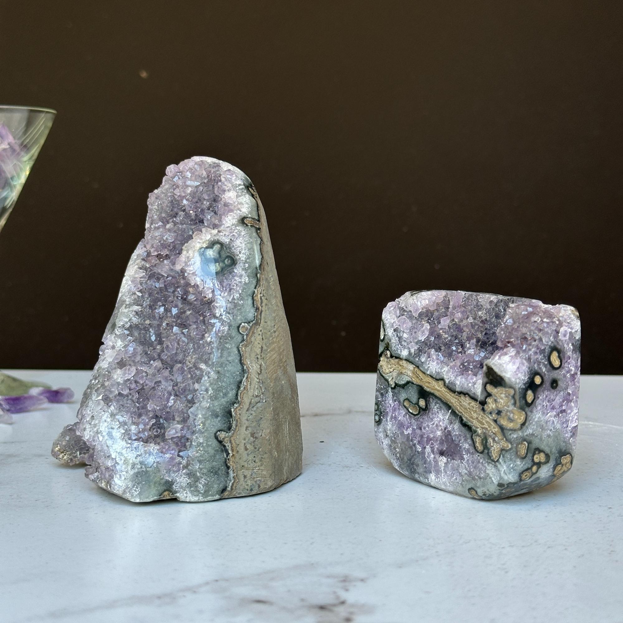 Two vibrant Uruguayan amethyst geode clusters with agate formations, one tall and one rectangular.