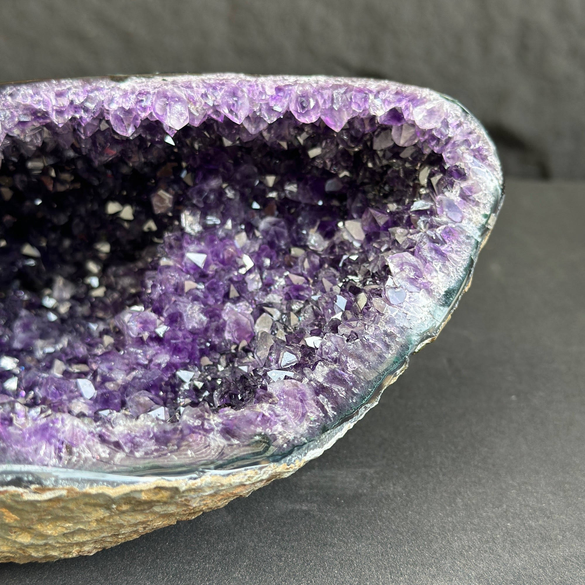 Close-up of a purple crystal geode on a dark gray background