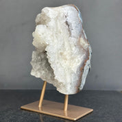 Geode crystal on a bronze stand against a gray background