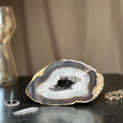 White quartz crystal geode cave with sparkling druzy, brown layers, and polished back.