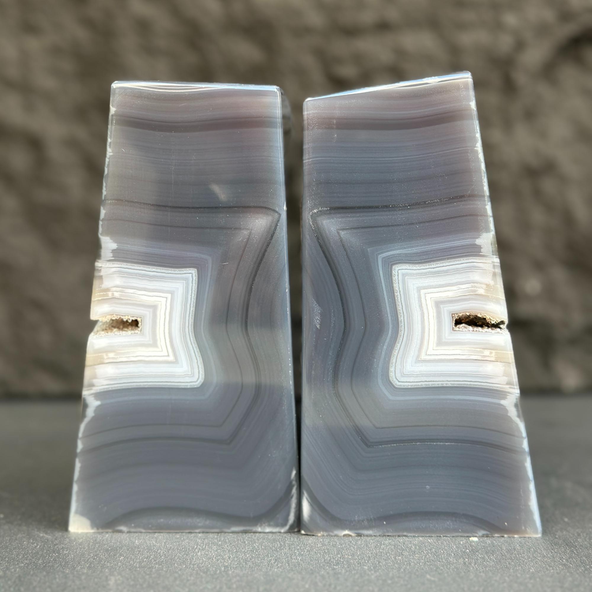 Two agate stone bookends with concentric pattern on a neutral background