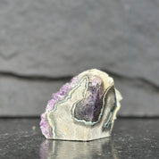 Mineral sample with purple and green colors on a dark surface