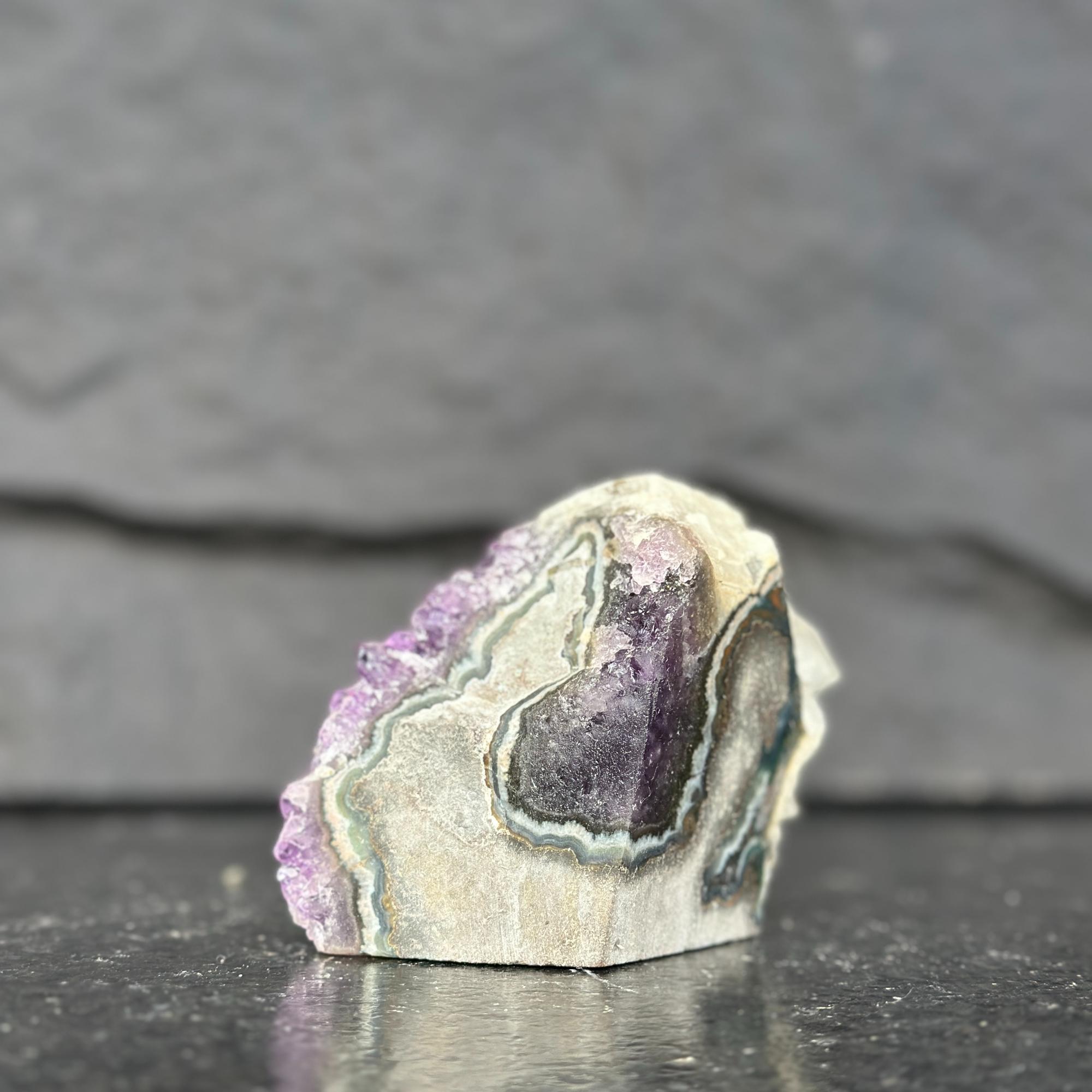 Mineral sample with purple and green colors on a dark surface