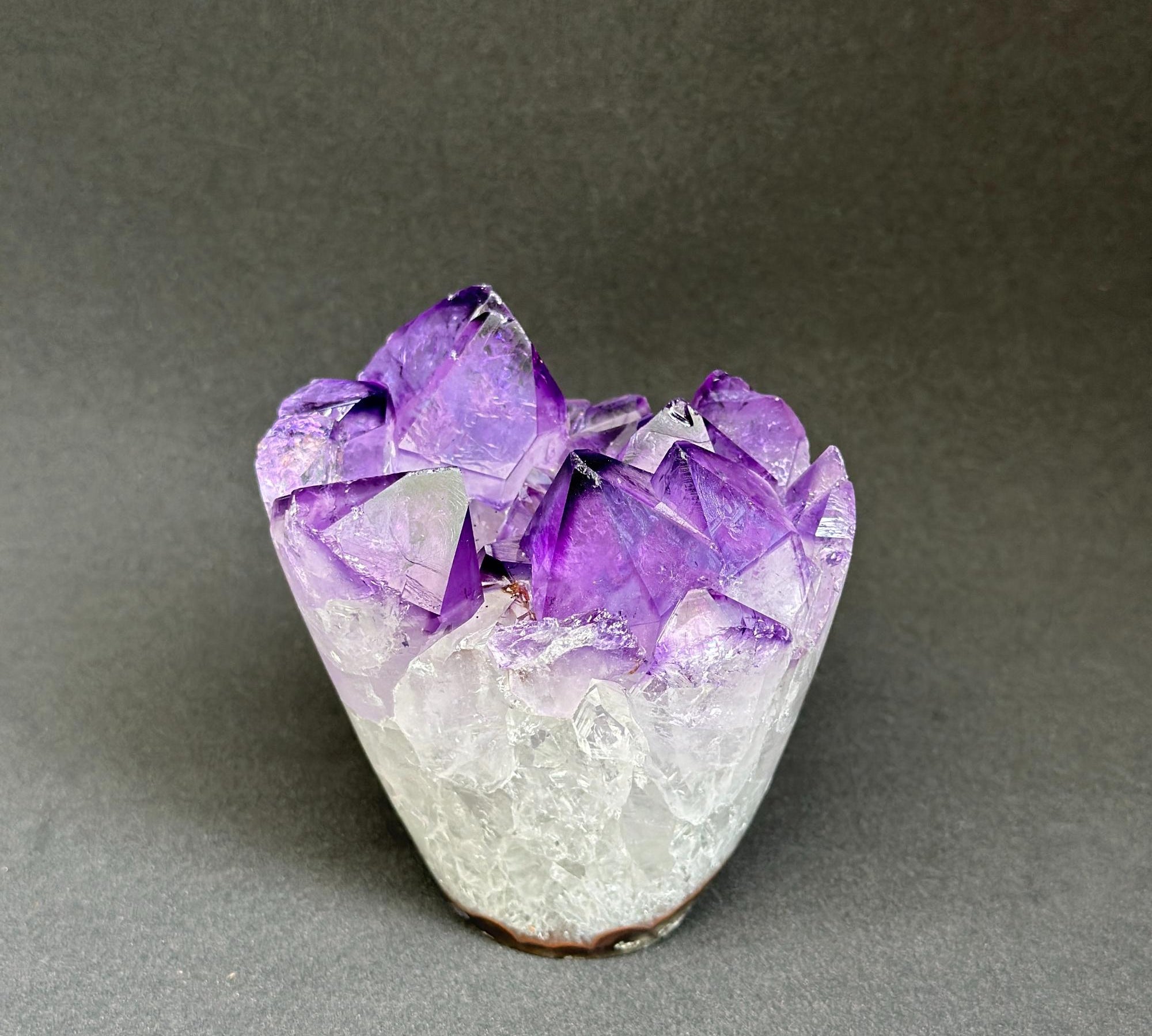 Amethyst crystal cluster on a gray background