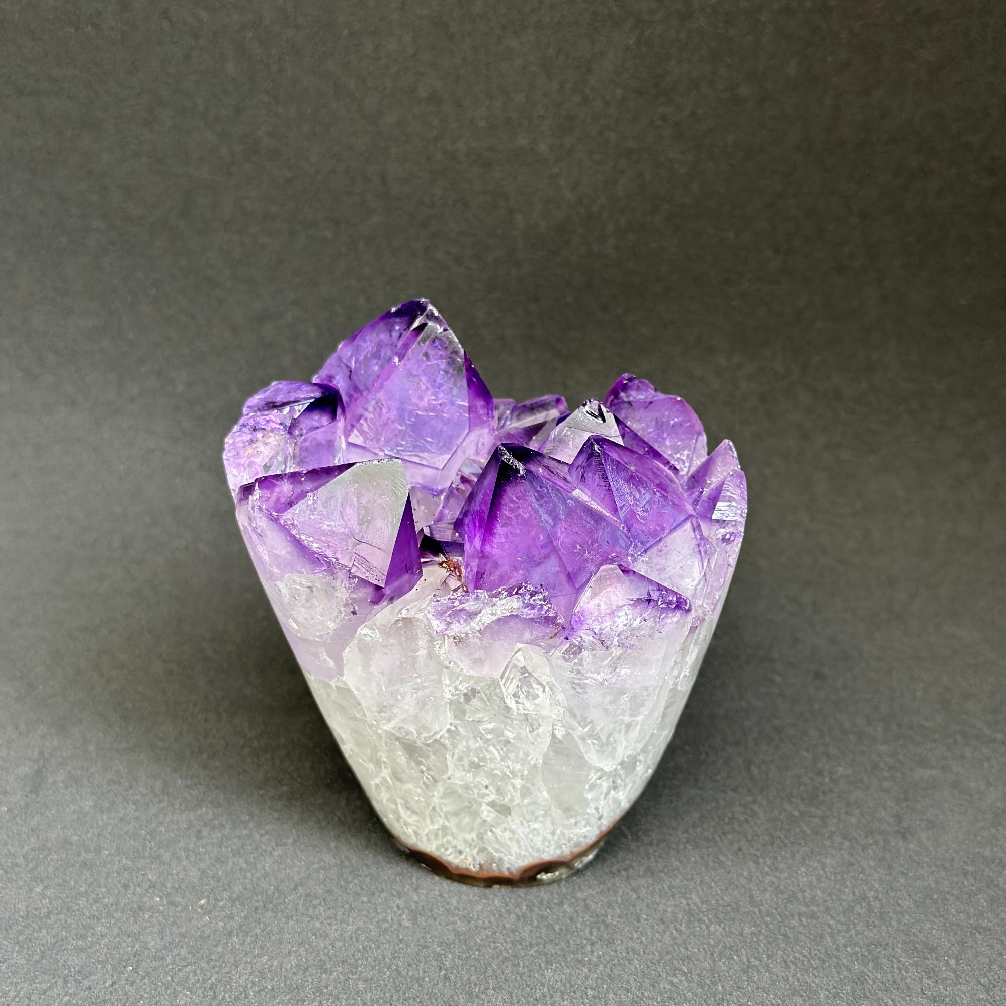 Amethyst crystal cluster on a gray background