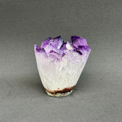 Amethyst crystal on a gray background