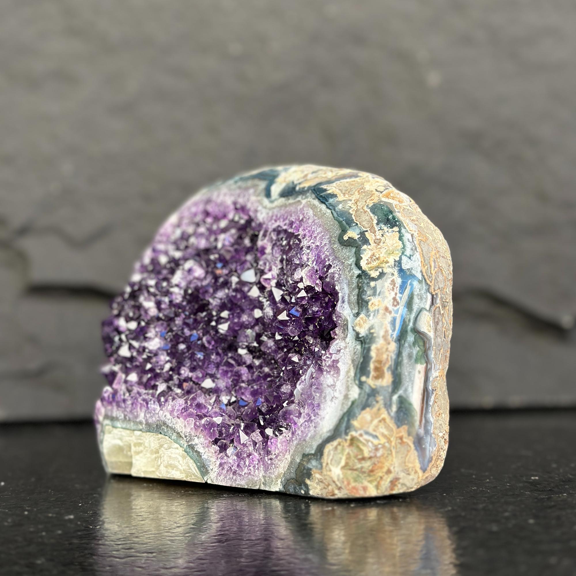 Geode with purple interior and textured surface on a dark background