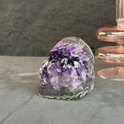 Amethyst crystal on a gray surface with a dark background