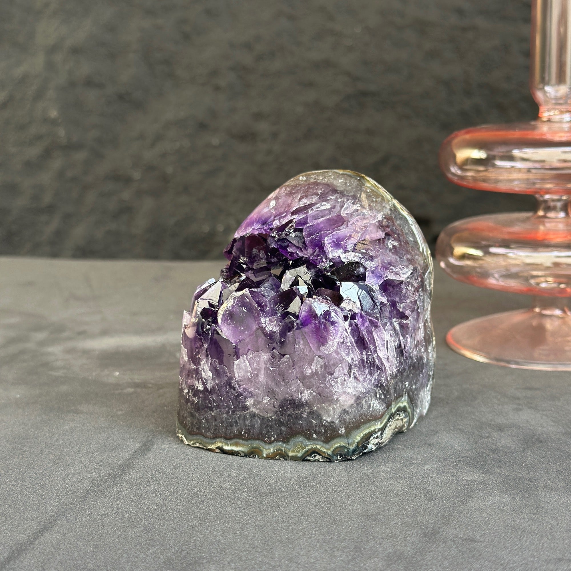 Amethyst crystal on a gray surface with a dark background