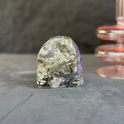 Mineral specimen on a gray surface with a blurred background