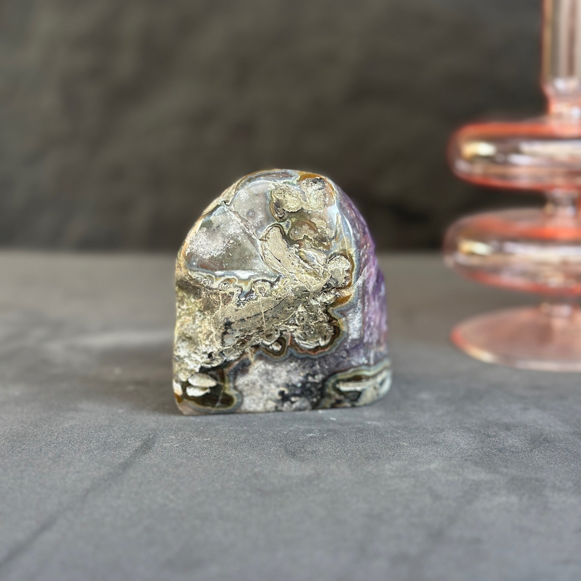 Mineral specimen on a gray surface with a blurred background