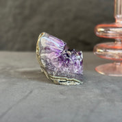 Amethyst crystal on a gray surface with a blurred background