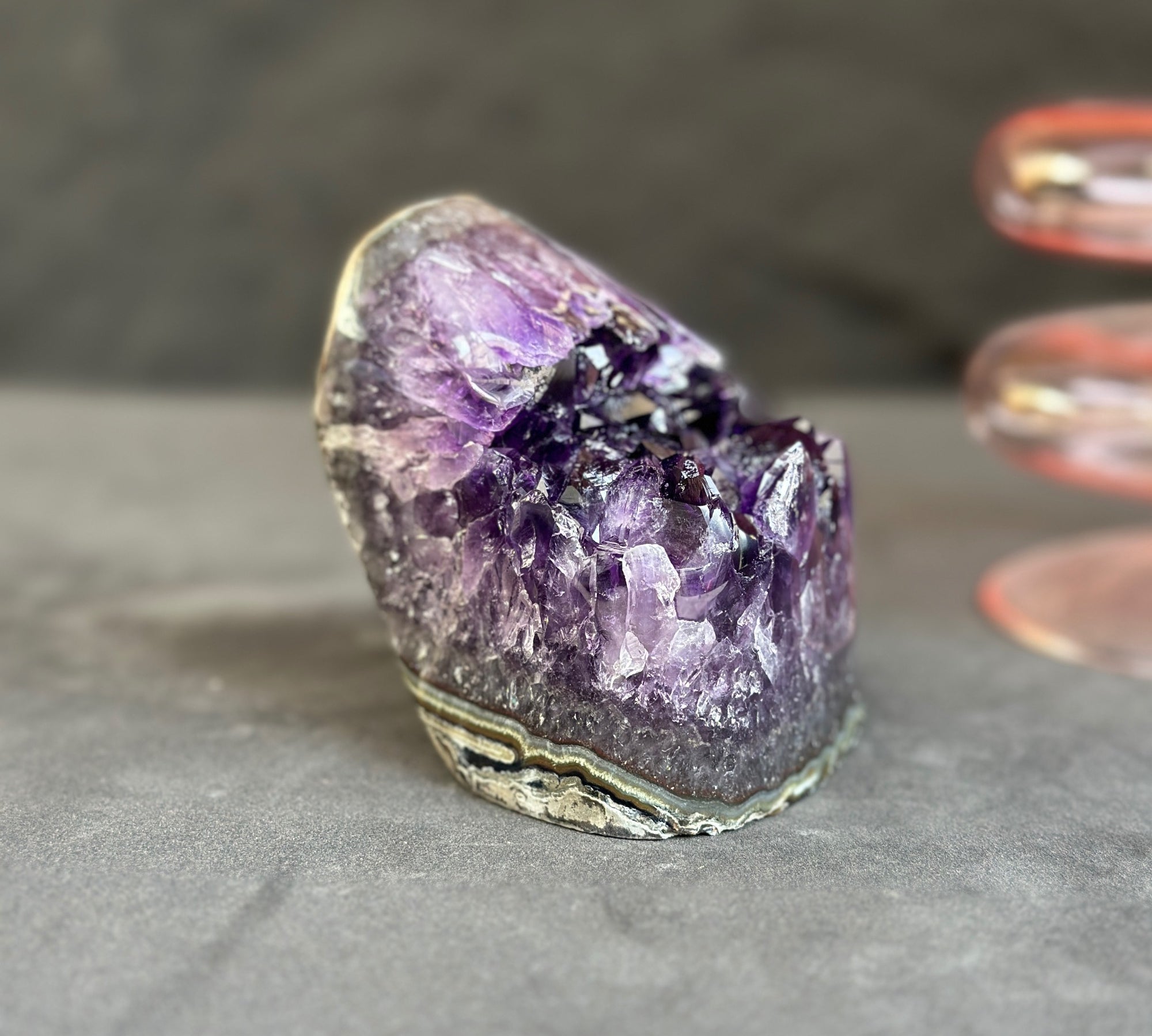 Amethyst crystal on a gray surface with a blurred background