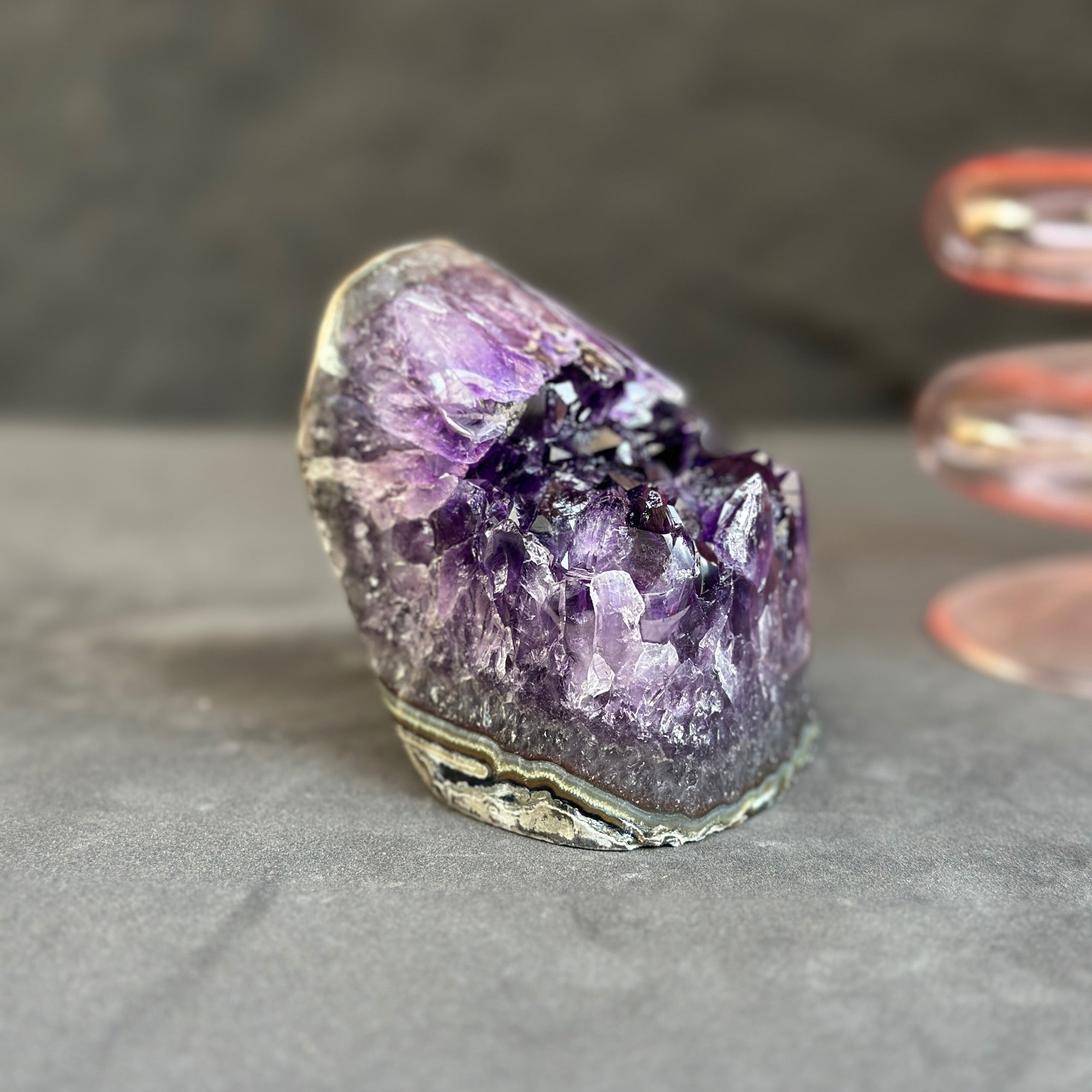 Amethyst crystal on a gray surface with a blurred background