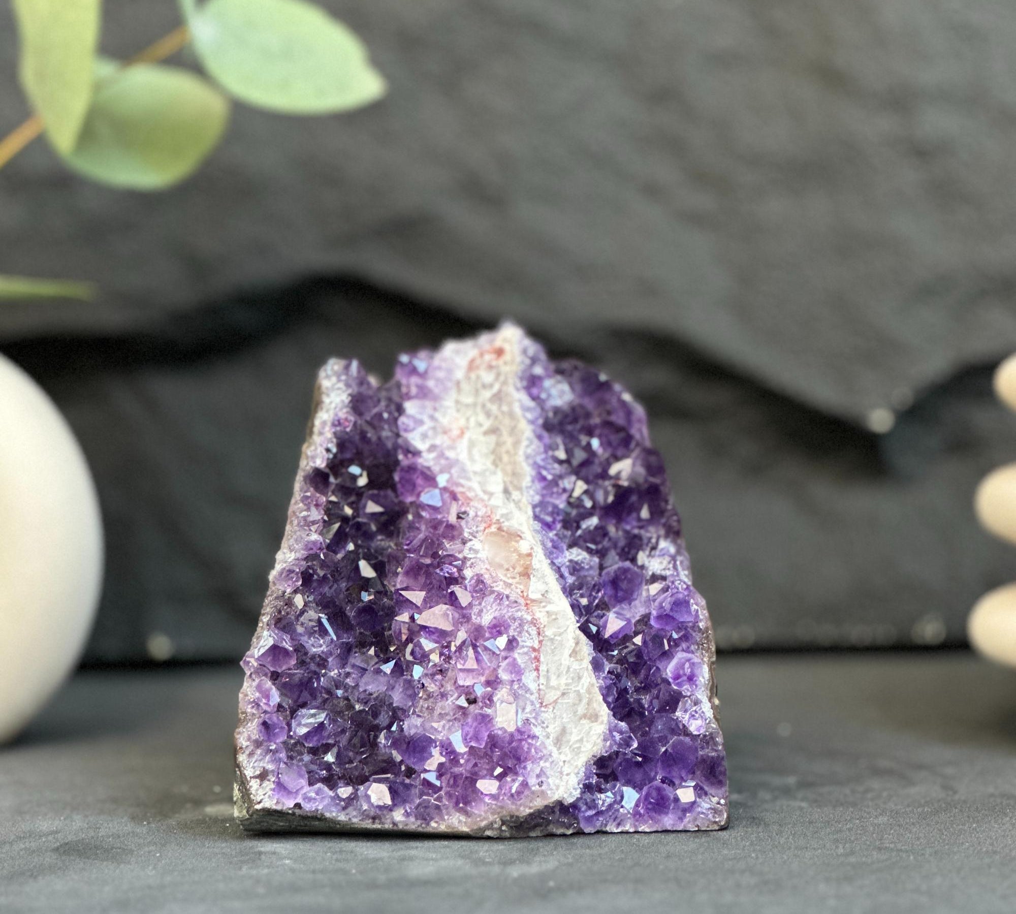 Amethyst crystal on a dark surface with a blurred background