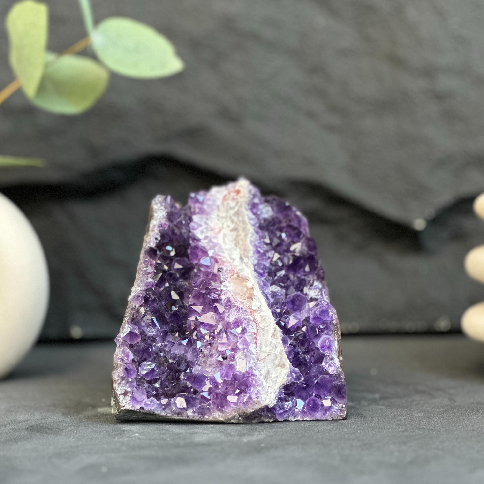 Amethyst crystal on a dark surface with a blurred background