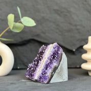 Amethyst crystal on a dark surface with decorative elements