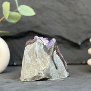 Mineral specimen with purple interior on a dark surface