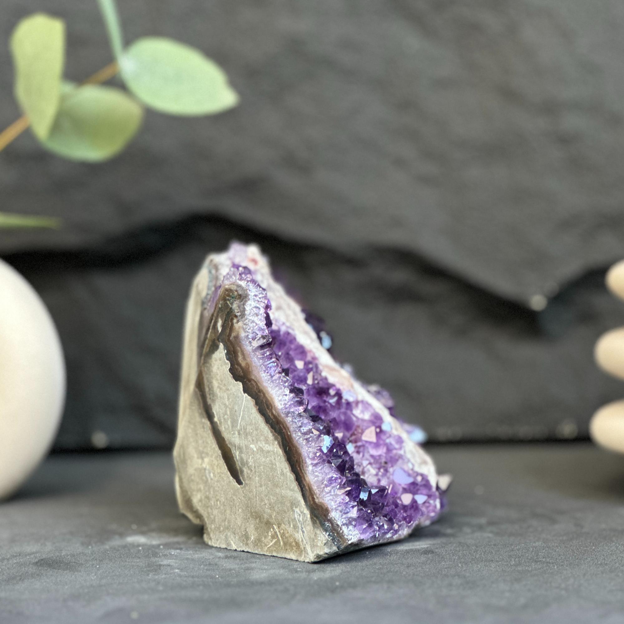 Amethyst crystal on a dark surface with a blurred background