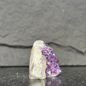 Mineral sample with purple crystal on a dark gray background