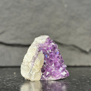 Amethyst crystal cluster on a dark slate background