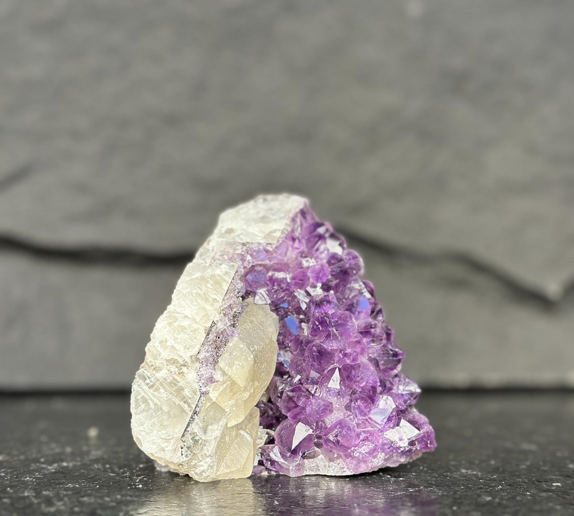 Amethyst crystal cluster on a dark slate background