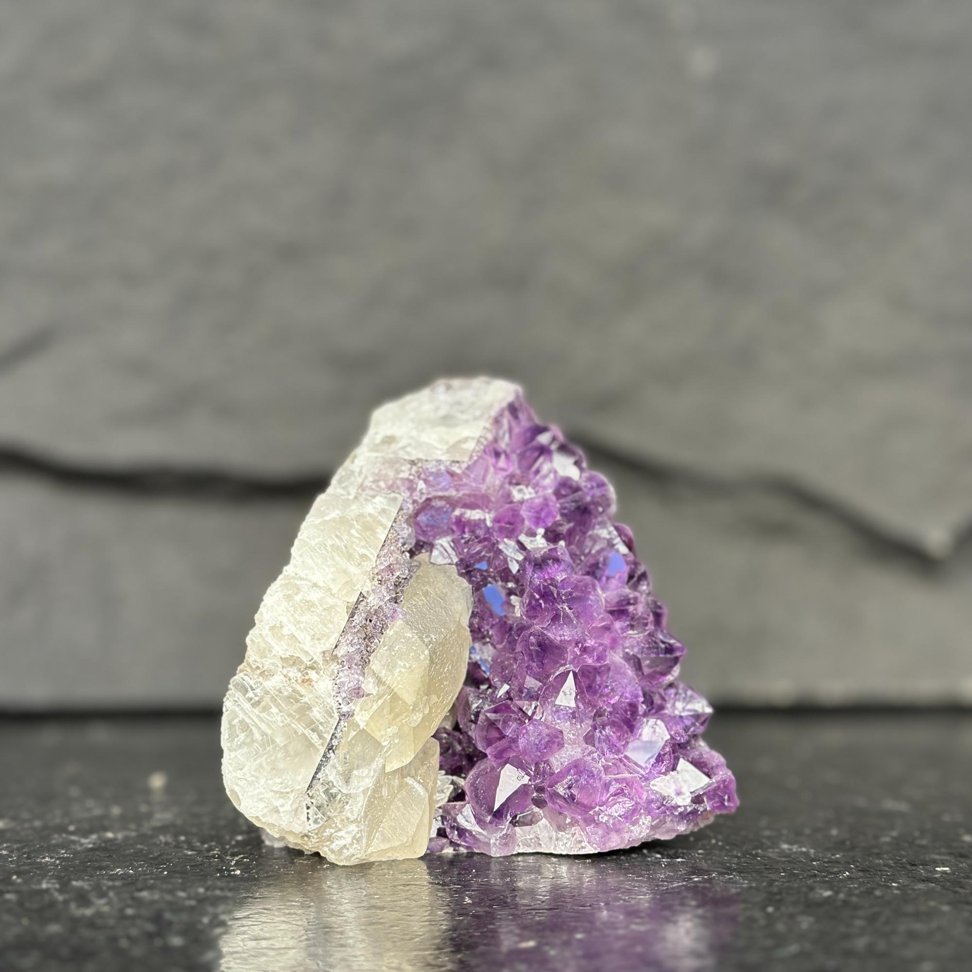 Amethyst crystal cluster on a dark slate background